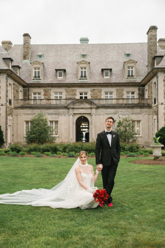 Bride and Groom photo in front of Aldrich Mansion with red bouquet. 